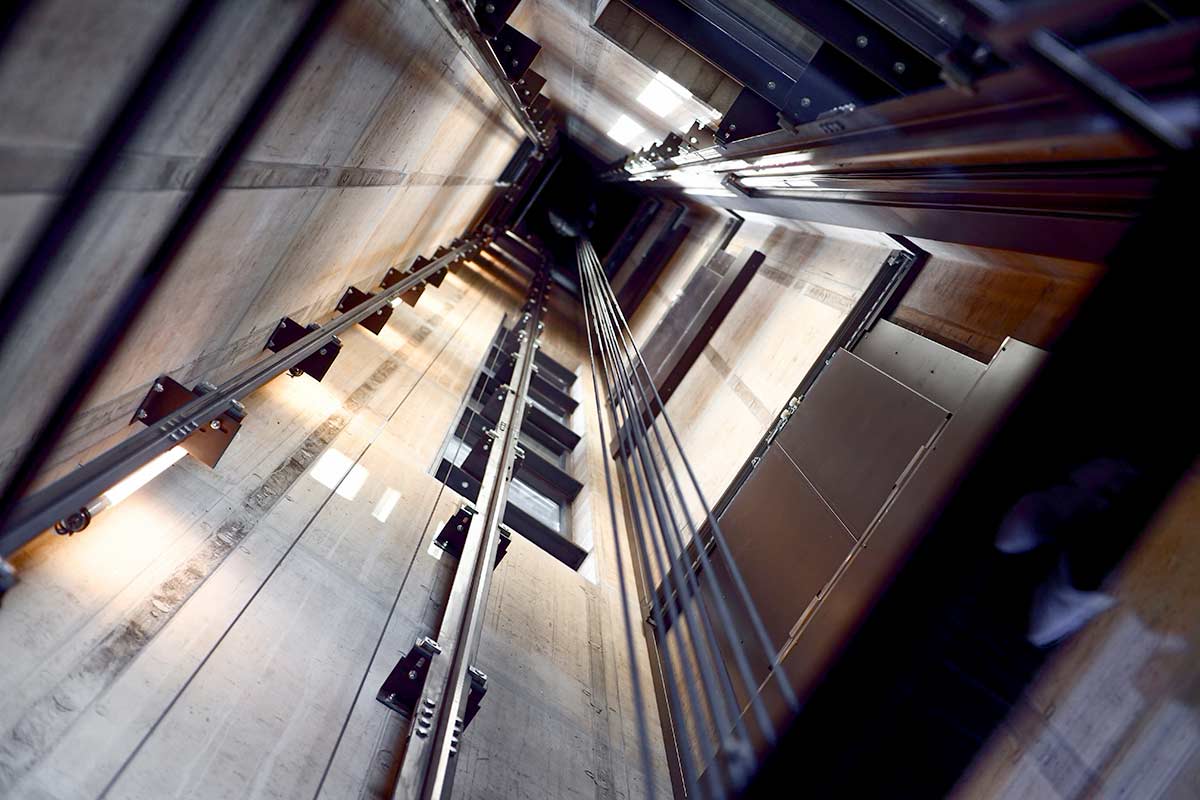 Blick von unten in einen Aufzugsschacht.